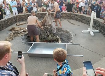 Crowd watching Hawaiian luau pit roast