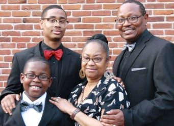 Family portrait in formal attire against brick wall