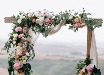 A wedding arch with flowers and greenery.