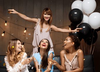 Here's an alt tag for the image: Friends celebrating with champagne and balloons.